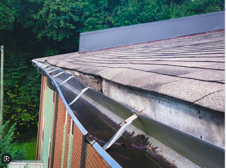gutter pulling away from house showing damaged fascia and probable need for replacement